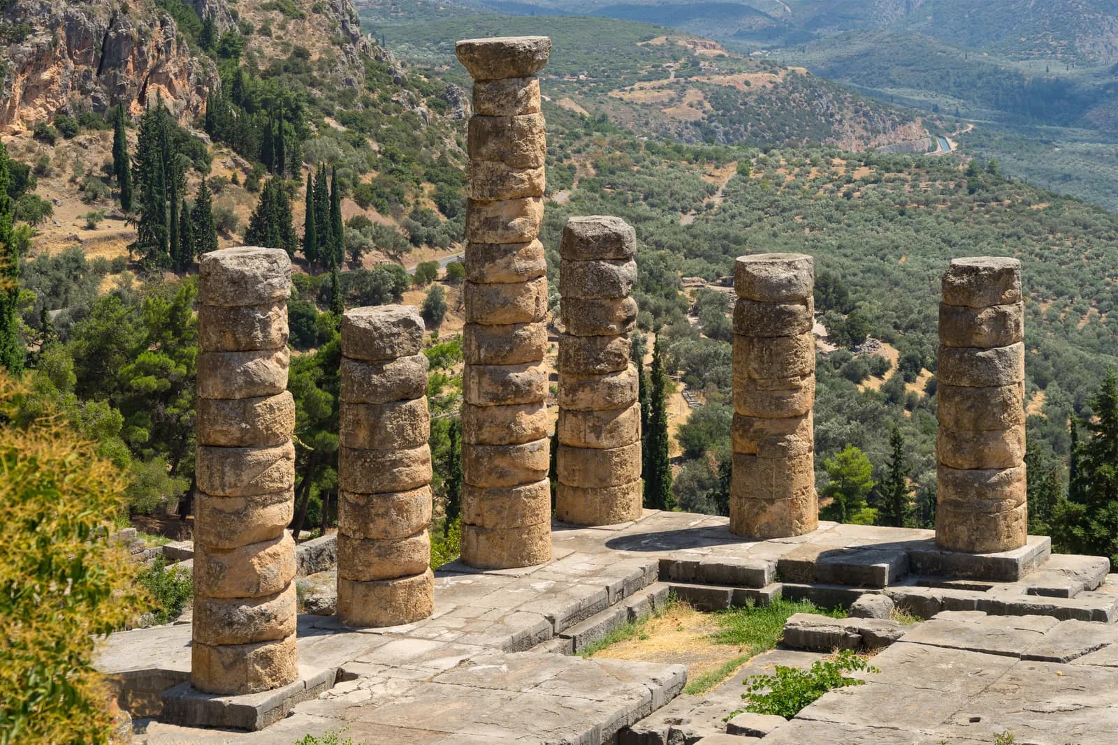 Six columns standing of the Temple of Apollo at Delphi, with the Phaedriades cliffs behind.