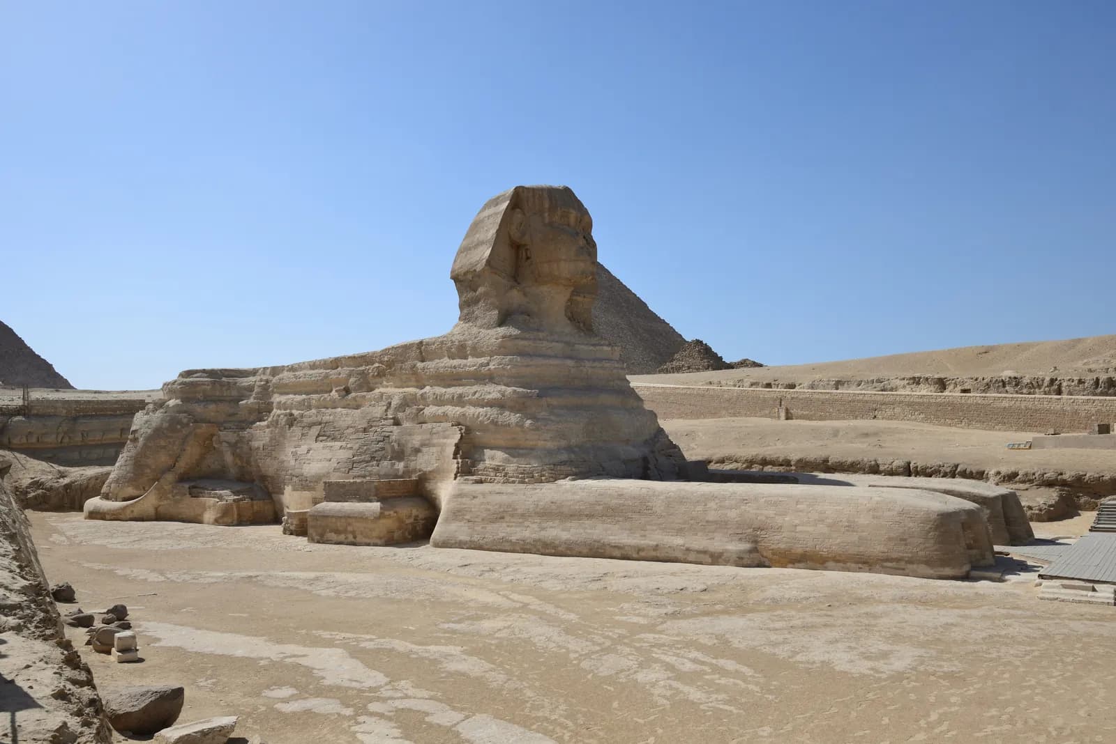 The Great Sphinx of Giza, the colossal recumbent lion with a human royal head carved from the living rock, with a pyramid behind it.