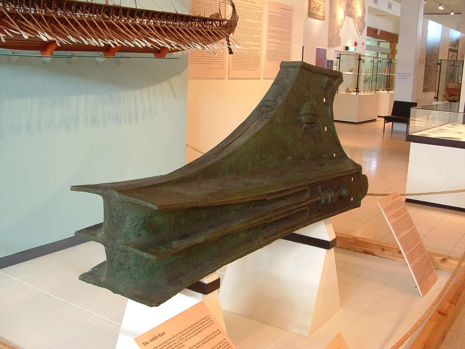 Large bronze casting shaped as a blunt three-finned head, the weapon fitted to the bow of an oared warship at the waterline.
