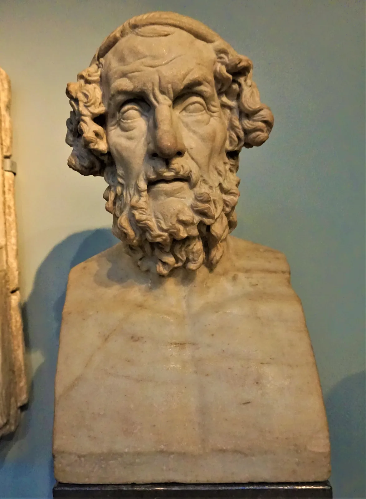 Marble portrait bust of a bearded, blind-looking elderly man, the conventional Hellenistic portrait type of Homer.