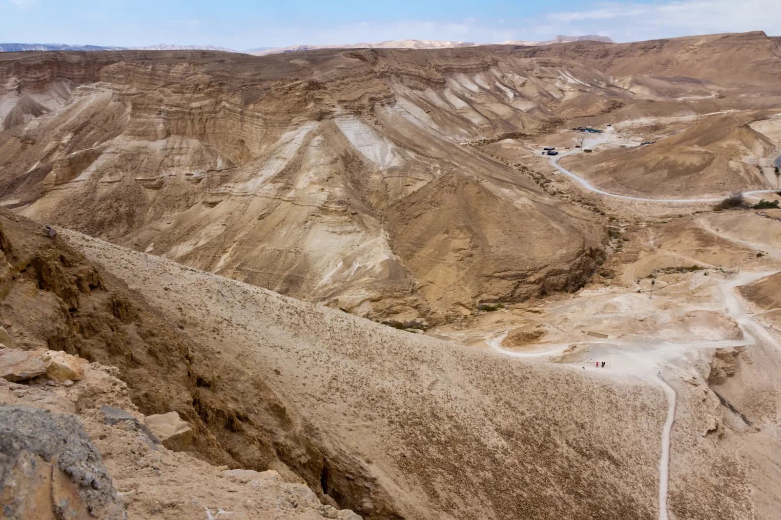 Great earthen ramp built up the side of a desert plateau toward a fortified summit.