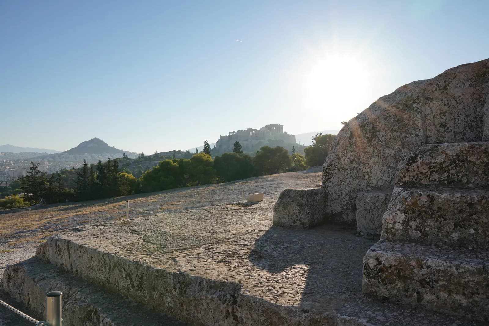 The view from the speaker's platform on the Pnyx hill toward the Acropolis of Athens and Mount Lycabettus — the ground on which the Athenian citizen assembly met and voted.