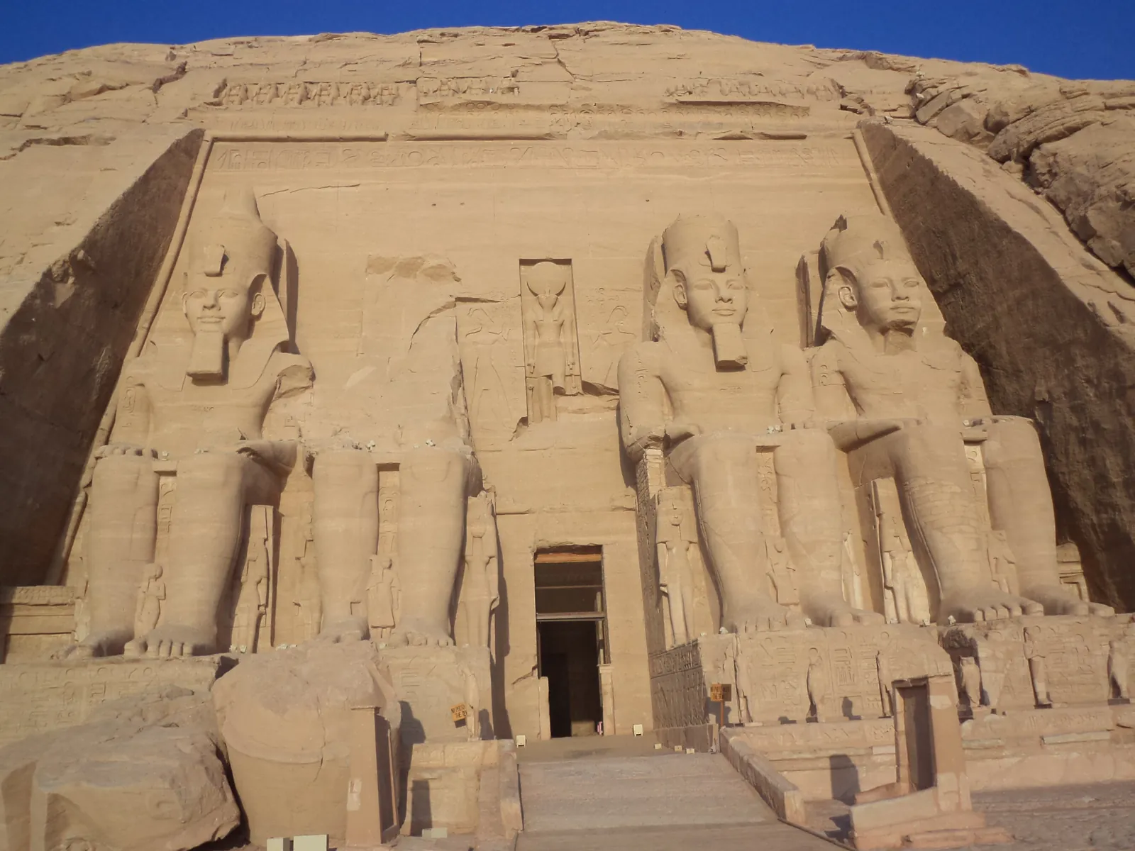 The facade of the Great Temple of Abu Simbel, cut from the cliff and fronted by four colossal seated statues of Ramesses II.